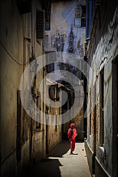 Veiled woman walking through a narrow street