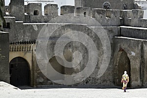 Veiled woman walks across Kasbar courtyard