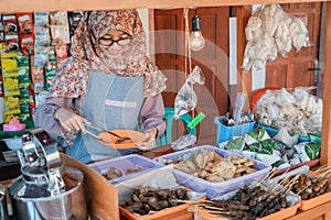 Veiled young woman selling the cart shop smiles when serving customer