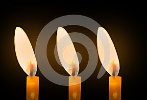 Veiw of three candle light isolated black background for design stock photo, candle flame burning