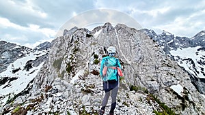 Velika Baba  - A hiking woman with helmet on a hiking trail in Kamnik Savinja Alps in Carinthia, Austria, Slovenia