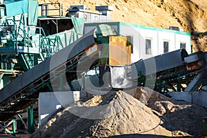 Velt conveyors and a piles of rubble in gravel quarry, crushed sand in different sizes