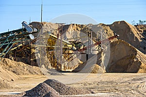 Velt conveyors and a piles of rubble in gravel quarry, crushed sand in different sizes