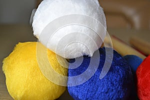 Velvet balls in red, blue, white and yellow, used as drum sticks.