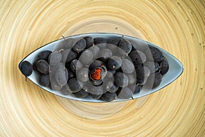 Velvet tamarind fruit  Dialium cochinchinense or buah keranji in a wooden bamboo plate background