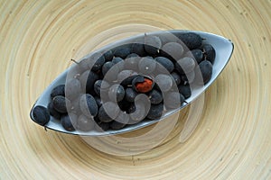 Velvet tamarind fruit  Dialium cochinchinense or buah keranji in a wooden bamboo plate background