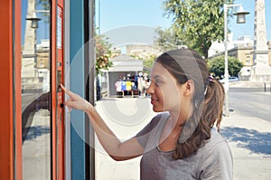 Vending machine. Attractive girl tanned buying drinks in summer. Young student or female tourist choosing a snack or drink at vend photo