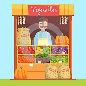 Vendor Behind Market Counter With Assortment Of Vegetables