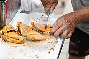 Vendor cutting delicious apam balik or peanut pancake into smaller pieces for sale