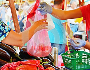 Vendor hands over a plastic bag to the buyer