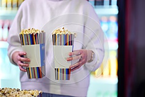 A vendor stands outside the cinema, holding freshly popped popcorn to sell to moviegoers before they enter the theater photo