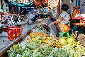 Vendors at famous Maeklong railway market selling fruit and vegetables at railway tracks, Samut Songkhram province, Thailand