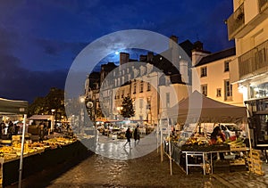 Vendors set up in early morning under a full moon for the Saturday Lices Market in Rennes, Brittany, France. photo