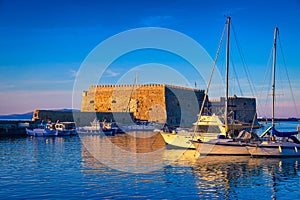 Venetian castle and fishing boats in bay of Heraklion, Crete, Greece