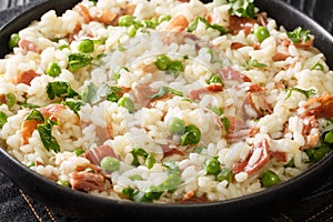 Venetian food Risi e Bisi of rice with peas and ham slices close-up in a plate. horizontal photo