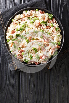 Venetian food Risi e Bisi of rice with peas and ham slices close-up in a plate. horizontal top view