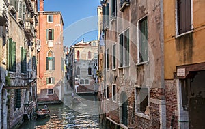 Venetian gondolier on small canal in Venice, Italy.