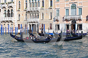 Venetian gondoliers in gondolas with tourists on Grand Canal, Venice, Italy