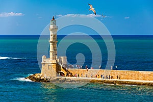 Venetian harbour and lighthouse in old harbour of Chania with seagulls flying over, Crete, Greece. Old venetian lighthouse in