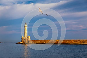 Venetian harbour and lighthouse in old harbour of Chania with seagulls flying over, Crete, Greece. Old venetian lighthouse in