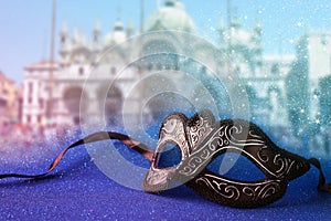 venetian mask in front of blurry Venice background. Glitter overlay