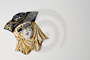 Venetian masks of white and black ceramic ornament with golden or gold highlights. White background