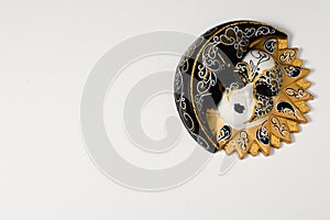 Venetian masks of white and black ceramic ornament with golden or gold highlights. White background