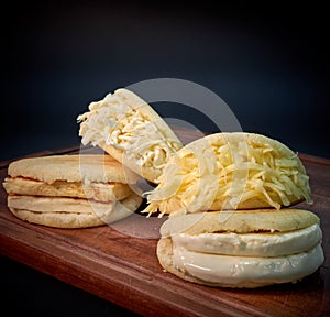 Venezuelan arepas filled with different types of cheese with wooden board photo