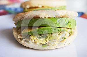 Venezuelan Arepas served on a table served with avocado and chicken