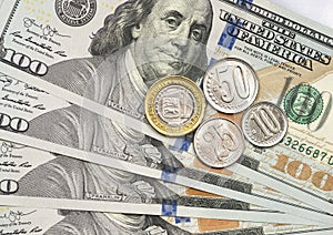 Venezuelan coin on top of dollar bills