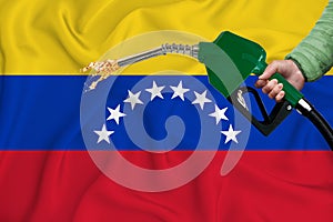 VENEZUELAN flag Close-up shot on waving background texture with Fuel pump nozzle in hand. The concept of design solutions. 3d