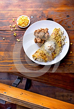 VENEZUELAN FOOD. Corn CACHAPA with cheese and fried pork - cochino frito. Wooden background, top view photo