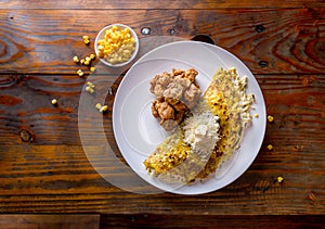 VENEZUELAN FOOD. Corn CACHAPA with cheese and fried pork - cochino frito. Wooden background, top view