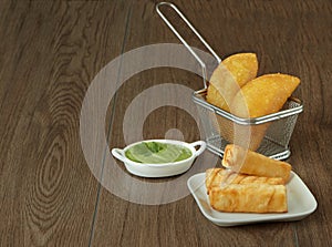 Venezuelan food, empanadas, tequeÃÂ±os and guacamole with wooden background photo