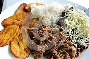 Venezuelan typical dish called Pabellon, made up of shredded meat, black beans, rice, fried plantain slices, and salty cheese. photo