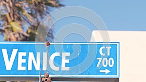 Venice beach street road sign, California city, USA. Tourist resort, palm trees