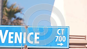 Venice beach street road sign, California city, USA. Tourist resort, palm trees