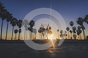 Venice beach Sunset in Los Angeles with a pedestrian walk during orange sunset. Empty beach