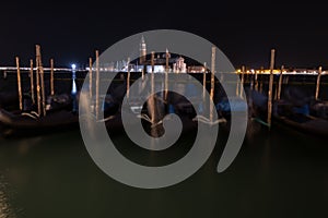 Venice canal with gondolas at night.