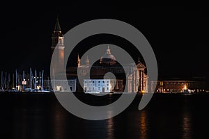 Venice canal with historical buildings and gondolas at night.