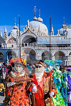 Venice with carnival masks against Mark`s Square in Italy