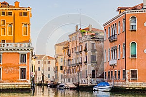 Venice cityscape - residential houses and boats on water canal