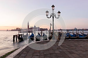 Venice classic sunrise view with gondolas on the waves