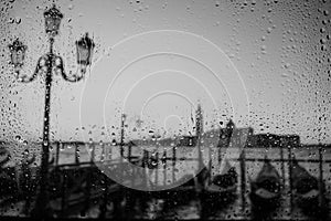 Venice Europe at rainy day weather water drops on the window with gondolas and sea
