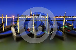 Venice gondole on a blue sunset twilight and San Giorgio Maggiore church landmark on background. Italy Europe