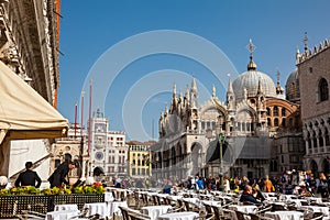 Restaurants and tourists at the famous Saint Mark Square of Venice in a beautiful sunny early spring