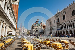 Restaurants and tourists at the famous Saint Mark Square of Venice in a beautiful sunny early spring