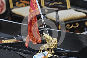 Venice, Italy - Closeup of a Venetian gondola in the rain with flag and coat of arms of the city of Venice, the