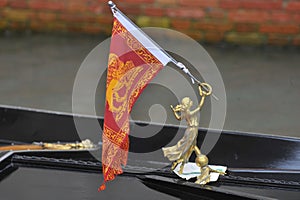 Venice, Italy Closeup of a Venetian gondola in the rain with flag and coat of arms of the city of Venice, the