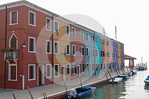 Venice, Italy. Colorful houses in Burano island. Canal view with boats.